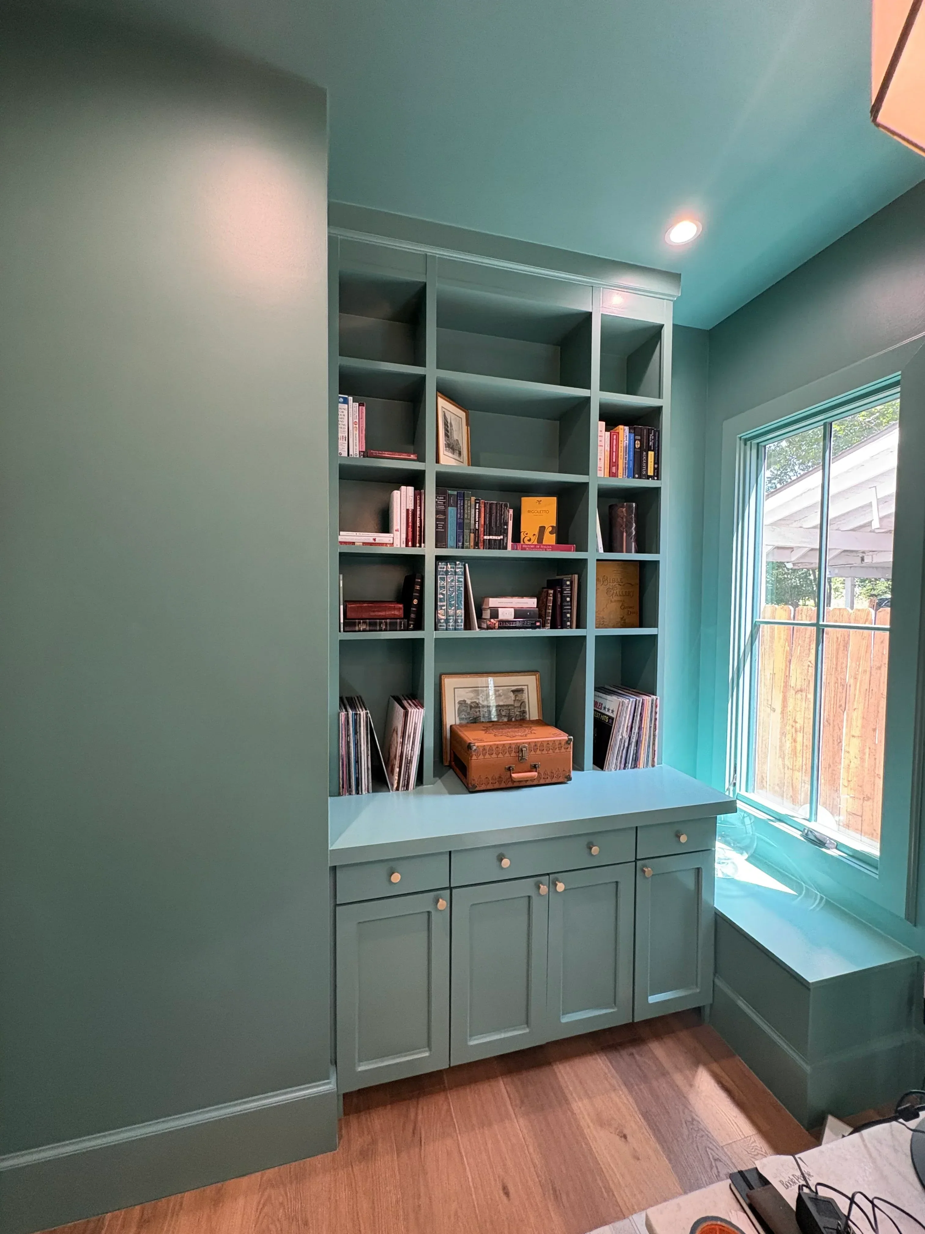 Turquoise painted built-in shelving unit with white trim and matching accent walls