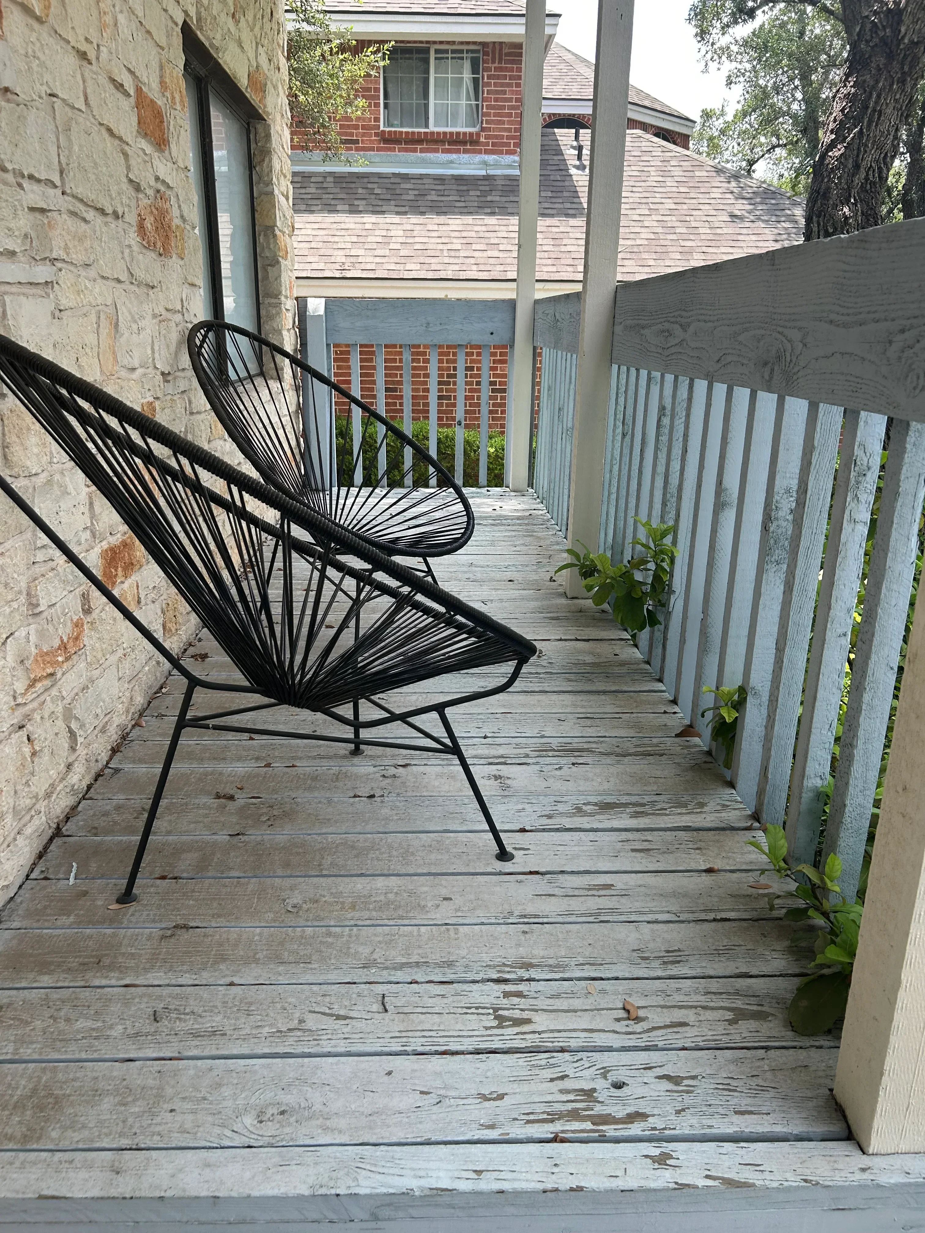 Painted pergola with horizontal slats and whitewashed wood walls in outdoor patio area