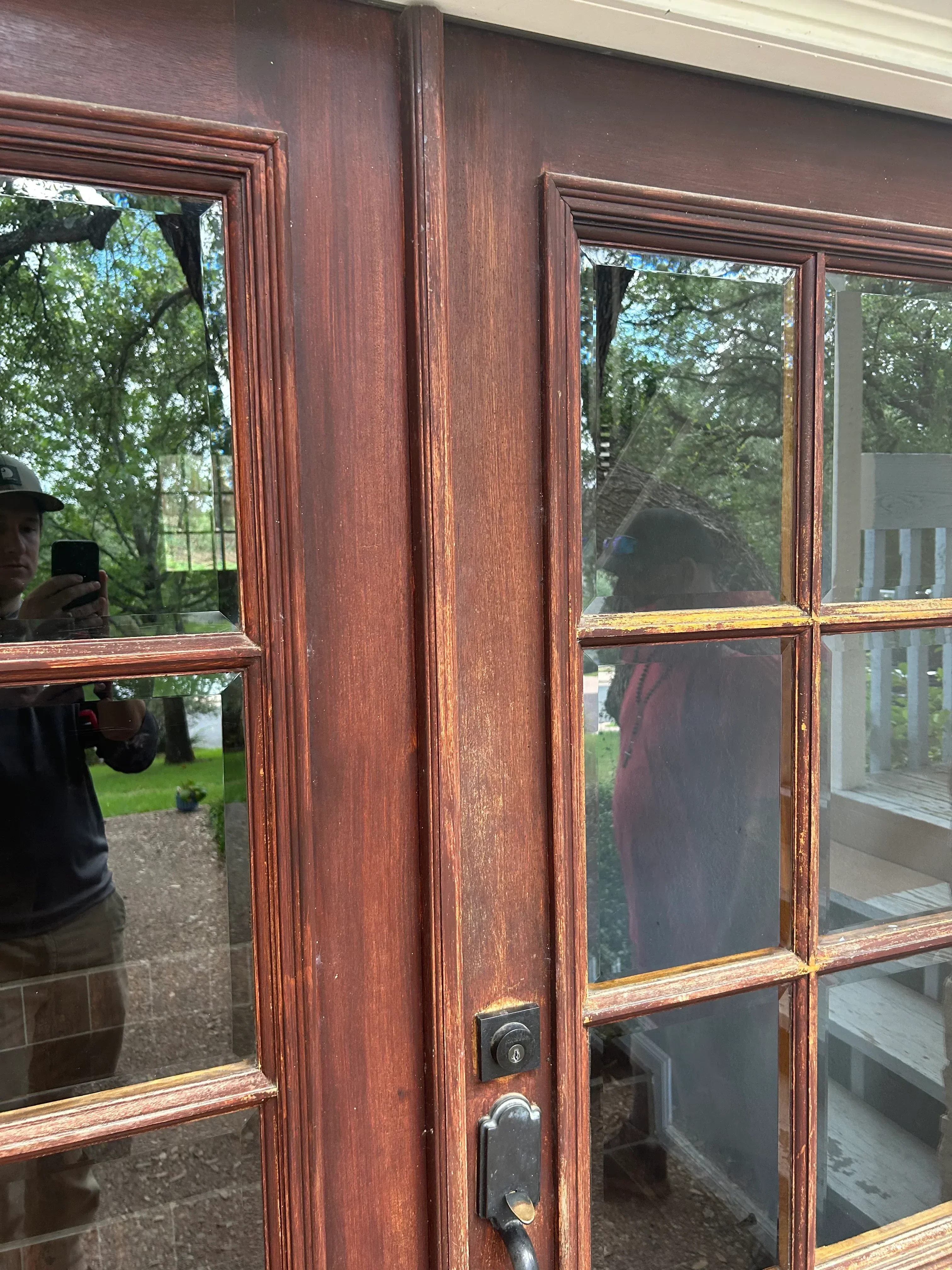 Wooden window frame with six panes, stained dark brown, showing detailed trim work and hardware