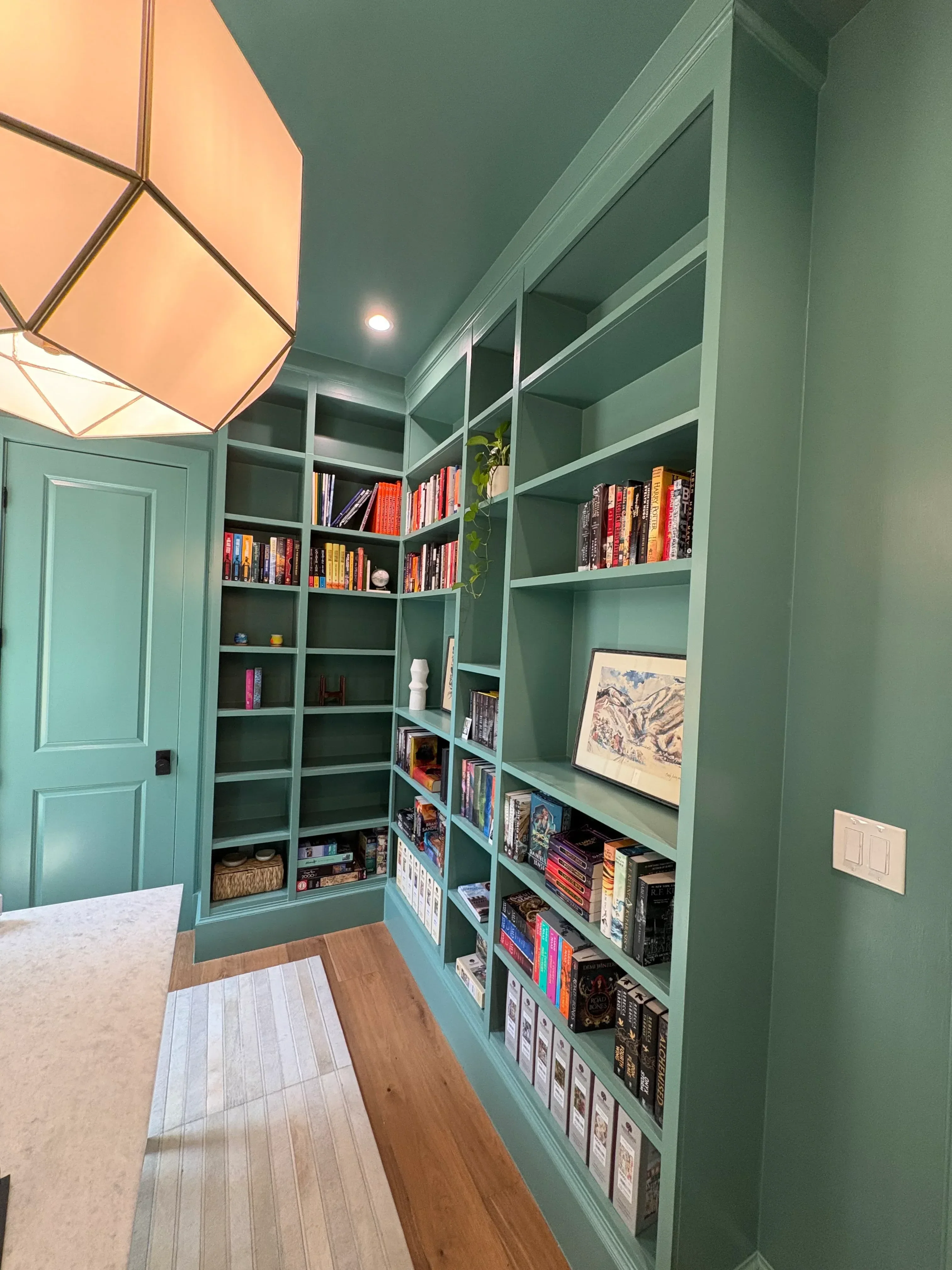 Sage green painted built-in shelving with grid cubicles and matching ceiling paint