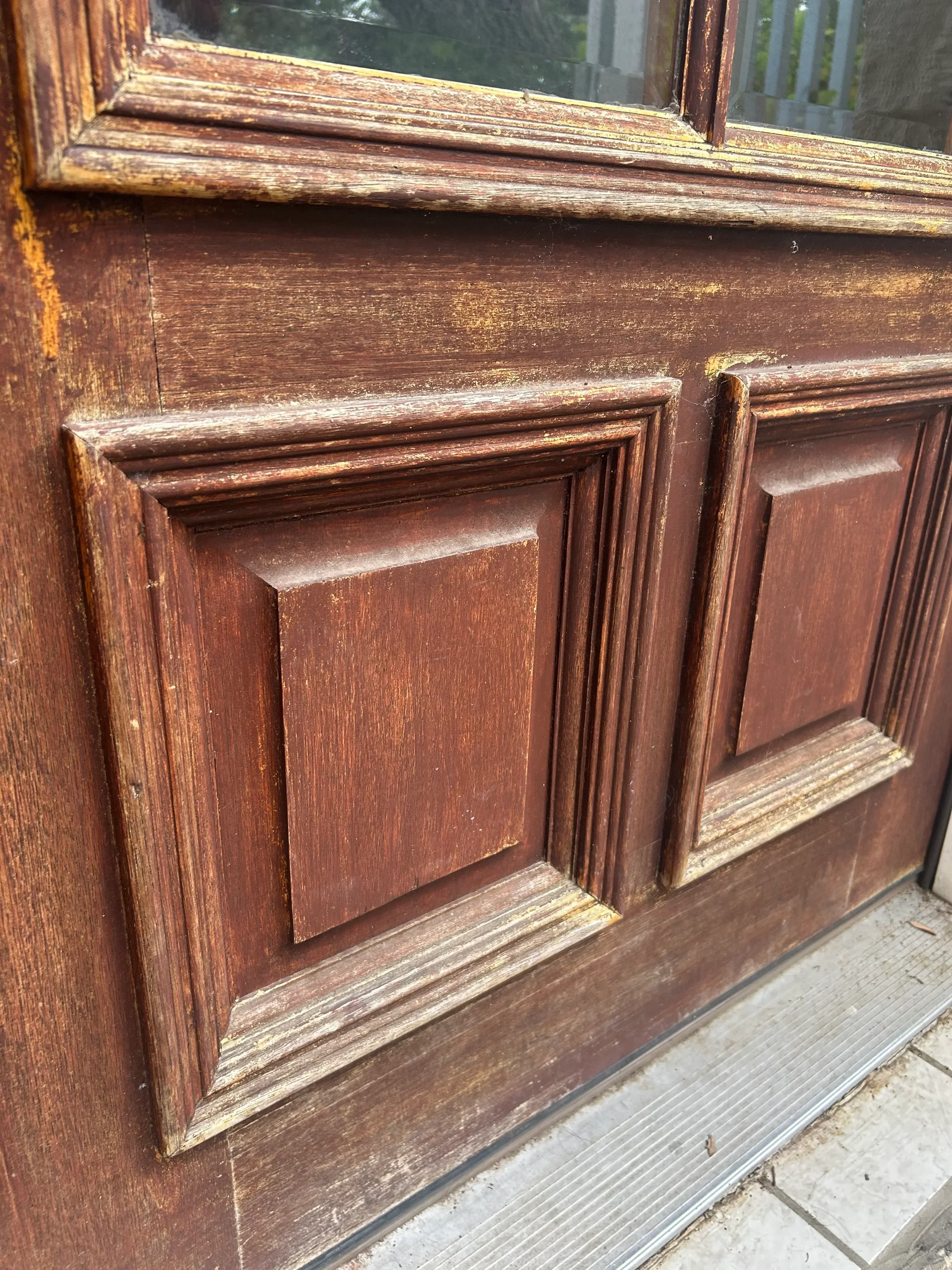 Refinished wood door with raised panels and stained frame molding